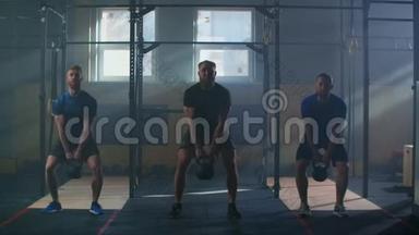 慢动作：三个朋友健身运动员，男子训练肌肉健美运动员，用壶铃做剧烈运动